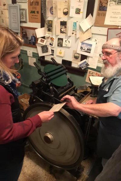 Andy prints souvenir cards on a letterpress for a Meander guest.